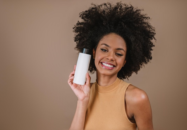 Beauty Latin woman with afro hairstyle Brazilian woman Holding blank shampoo packaging