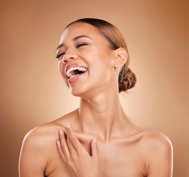 Photo beauty laughing and a woman happy with skin care glow and shine in studio on a brown background face of aesthetic female model satisfied with spa facial dermatology cosmetics and wellness