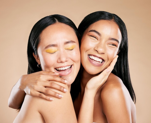 Beauty love and diversity with model woman friends in studio on a beige background for natural skincare Makeup health and wellness with an attractive young female holding the head of her friend