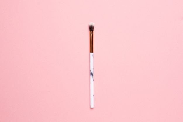 Beauty make up brush on a pink background top view