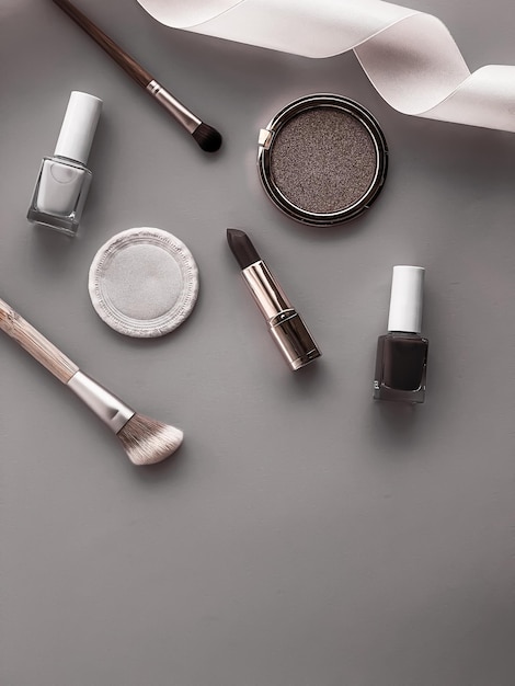 Beauty makeup and cosmetics flatlay design with copyspace cosmetic products and makeup tools on gray background girly and feminine style