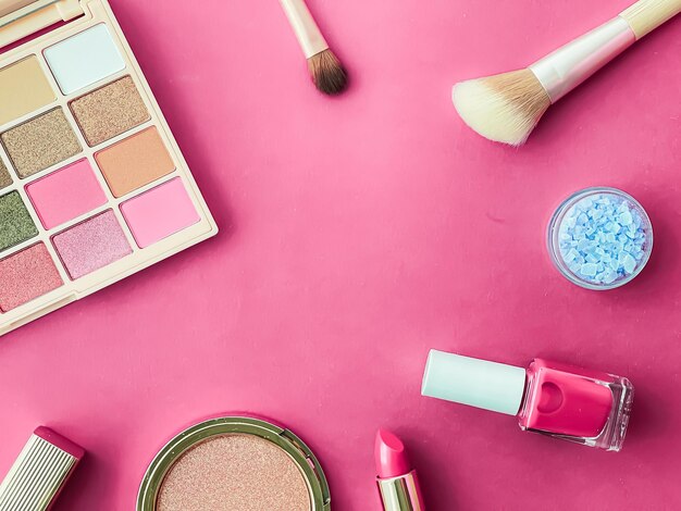 Beauty makeup and cosmetics flatlay design with copyspace cosmetic products and makeup tools on pink background girly and feminine style concept