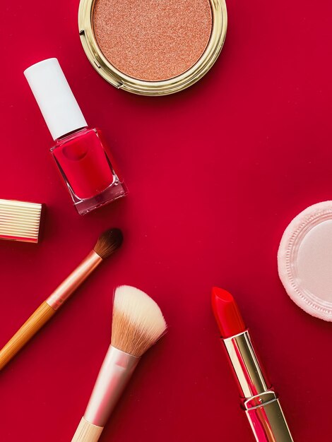 Beauty makeup and cosmetics flatlay design with copyspace cosmetic products and makeup tools on red background girly and feminine style concept