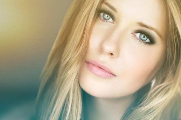 Красивый макияж и гламурный взгляд красивой блондинки с длинной прической и дымчатыми глазами вечерней ма...