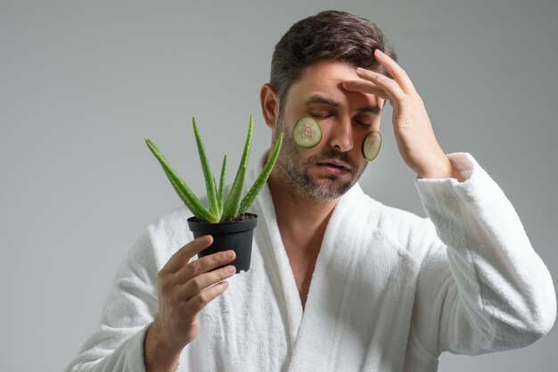 Foto uomo di bellezza tenere aloe vera uomo di mezza età con aloe vera isolato sullo sfondo dello studio aloe vera per