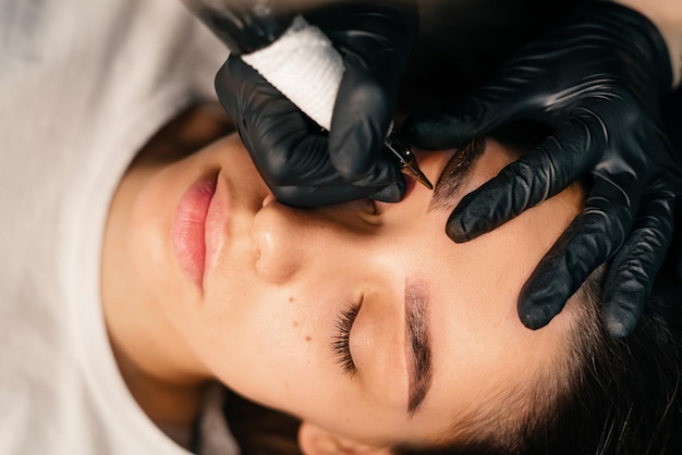 Beauty masters hands do permanent eyebrow makeup Minimal trauma to skin Eyebrow microblading is performed using manipulator handle and special nozzle with needles Cosmetologist skill level