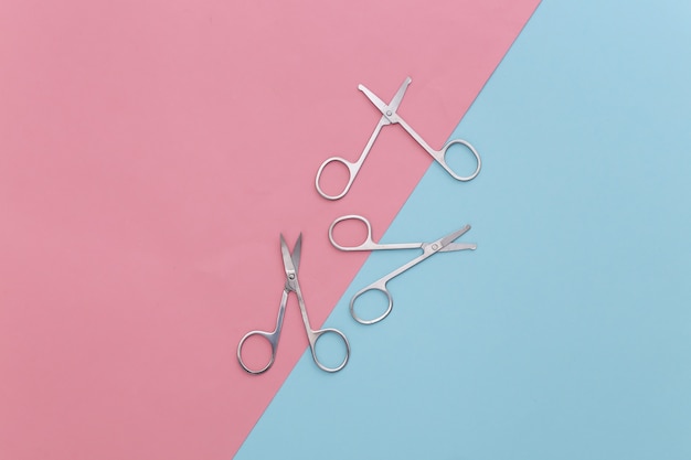 Beauty minimalism. Manicure scissors on pink blue. Nail care