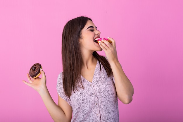 Beauty model girl eating colorful donuts.