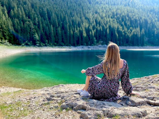 자연과 사람의 아름다움 Durmitor 호수와 산에서 놀라운 전망을 감상하며 앉아 있는 소녀