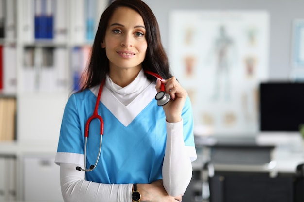 Beauty nurse in blue scrubs against clinic medical office