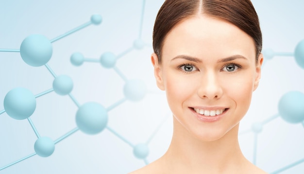 Photo beauty, people and health concept - beautiful young woman face over blue background with molecules