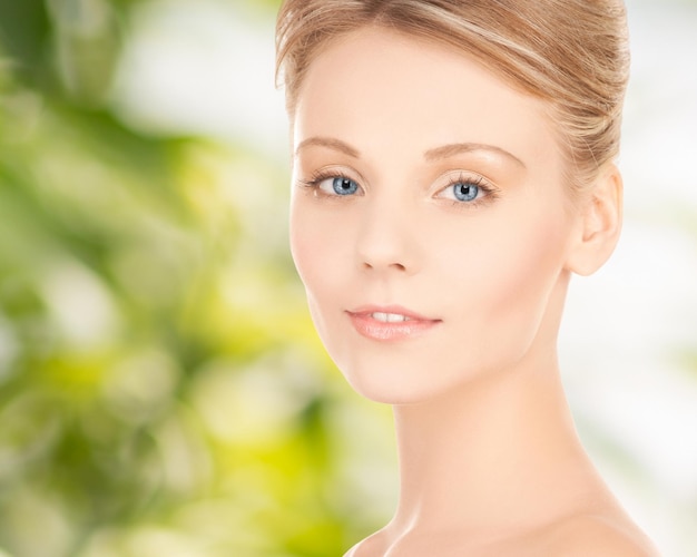 beauty, people and health concept - beautiful young woman face over green background