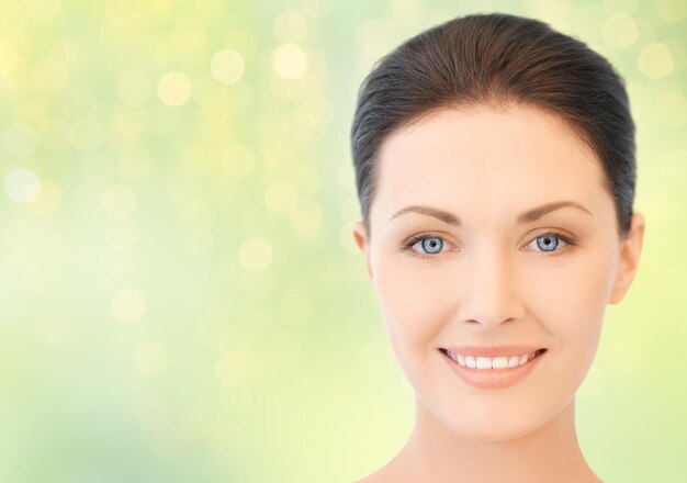 Photo beauty, people and health concept - close up of beautiful young woman face over green lights background