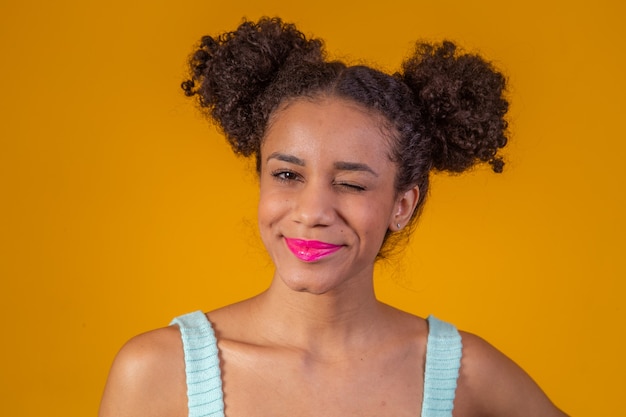 Beauty portrait of african american woman with afro hairstyle and glamour makeup. brazilian woman. mixed race. curly hair. hair style. yellow background. afro woman smiling at the camera