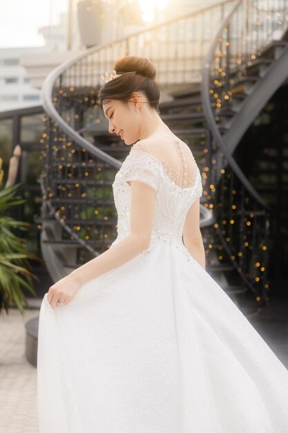 ダイヤモンドの指輪とトレンディな化粧を顔に施した豪華なファッションのウェディングドレスを着たアジアの美しさの花嫁の美しいポートレートとても誇りに思って幸せを感じています