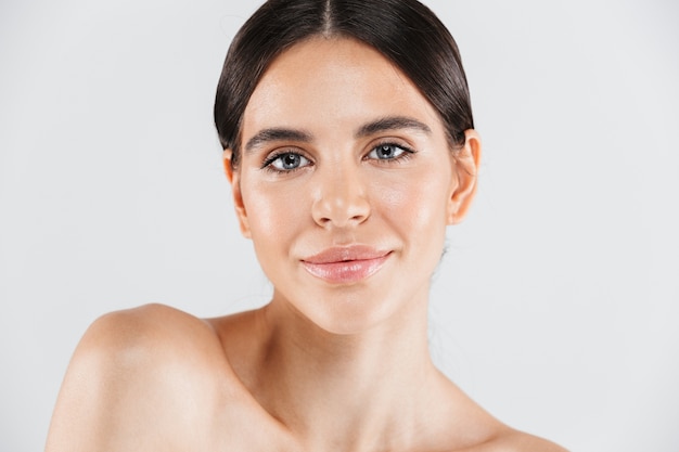 Beauty portrait of an attractive healthy woman standing isolated over white wall, posing