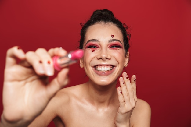 Beauty portrait of an attractive young topless woman wearing makeup standing isolated 