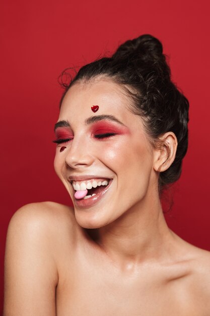 Beauty portrait of an attractive young topless woman wearing makeup standing isolated 