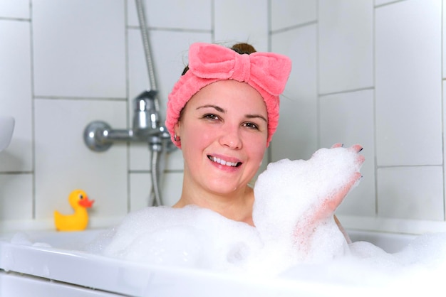 Beauty portrait of beautiful happy positive girl young cheerful woman is relaxing lying in bathroom