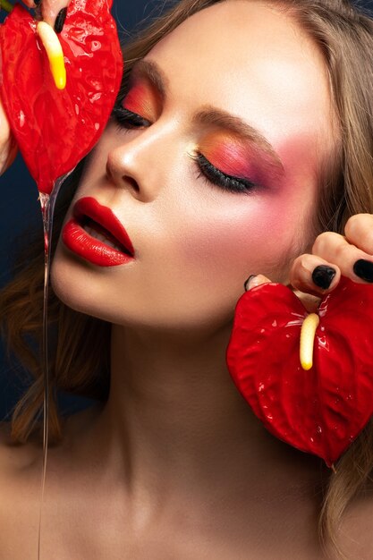 Beauty portrait of a beautiful model with a bright make-up and red lips close-up.