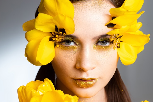 Photo beauty portrait of a brunette with extended eyelashes in the image of a tulip. on a white