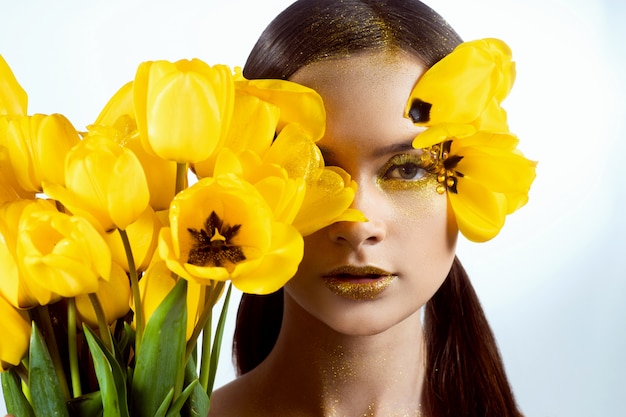 Beauty portrait of a brunette with extended eyelashes in the image of a tulip.