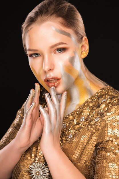 Foto ritratto di bellezza della modella bionda glamour con vernice oro e argento sulle spalle e sul viso