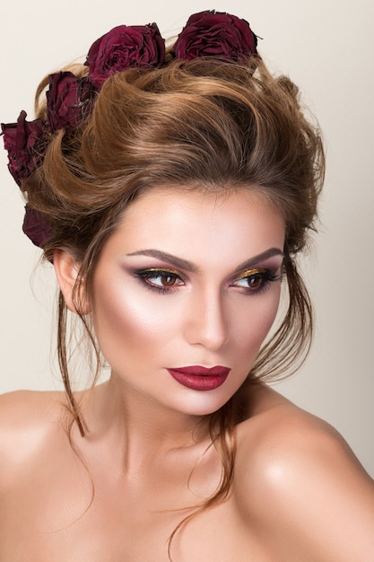 Beauty portrait of gorgeous adult woman with roses in her hair