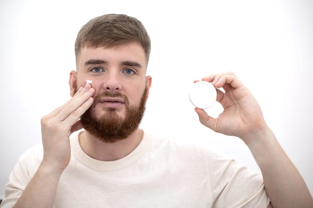 Beauty portrait of handsome happy young bearded man with beard and perfect skin on white background