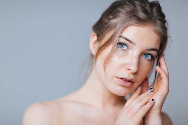 Beauty portrait of a lovely woman posing over gray background