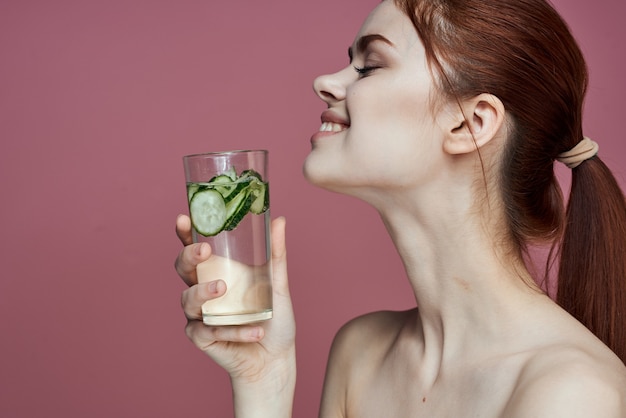 Фото Красота портрет девушки молодой женщины со стаканом воды с чистой кожицей огурца