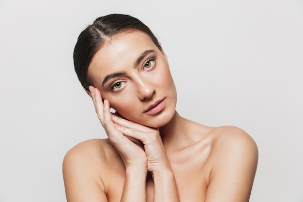 Beauty portrait of a pretty young topless woman standing isolated, posing