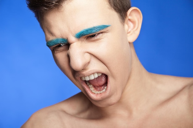 Beauty portrait of screaming handsome caucasian male with creative makeup