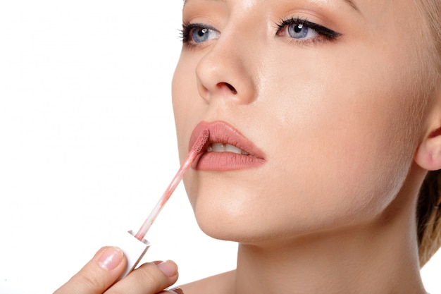 Beauty portrait of a smiling beautiful half naked woman posing with make-up brushes