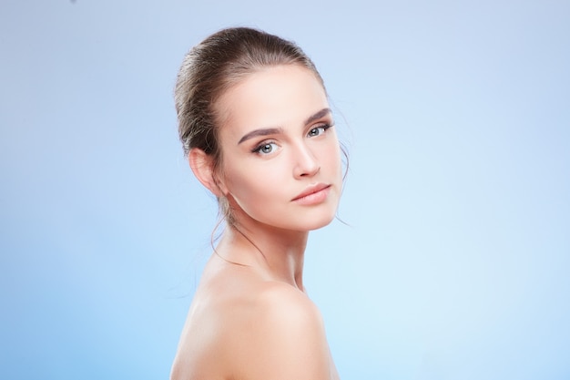 Beauty portrait of woman looking at camera, semi profile. Head and shoulders of tender woman with nude make-up, beauty concept, closeup, turned aside.