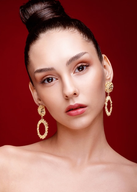 Beauty portrait of woman posing with golden earrings