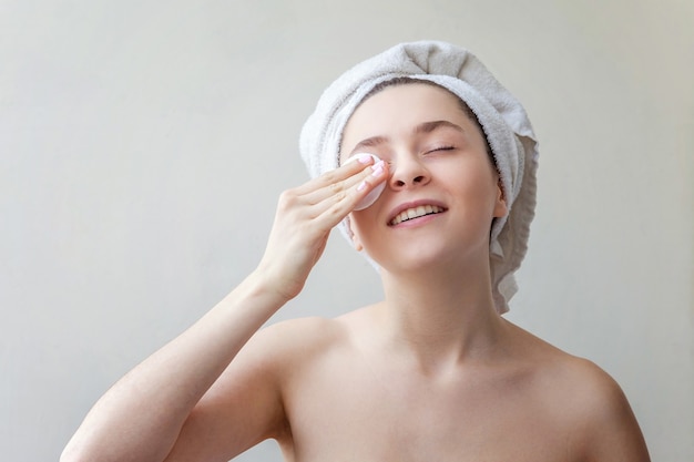 Beauty portrait woman removing make up with cotton pad isolated on white