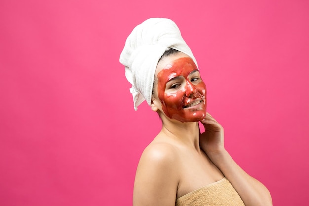 Beauty portrait of woman in white towel on head with gold\
nourishing mask on face skincare cleansing eco organic cosmetic spa\
relax concept