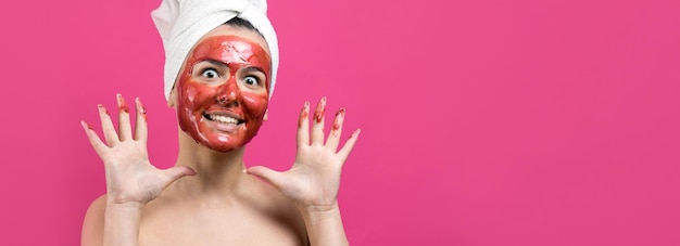 Beauty portrait of woman in white towel on head with gold nourishing mask on face