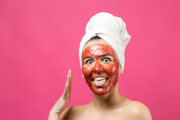 Beauty portrait of woman in white towel on head with gold nourishing mask on face