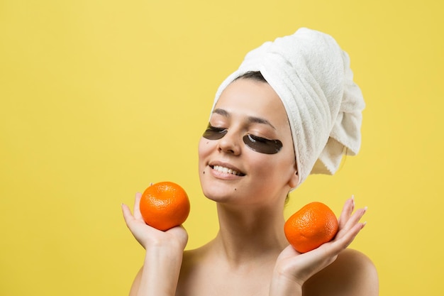 Beauty portrait of woman in white towel on head with gold nourishing mask on face