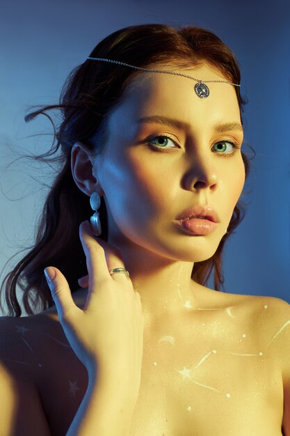 Beauty portrait of a woman with beautiful makeup, earrings and a necklace on the girl