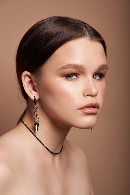 Beauty portrait of a woman with jewelry, earrings in her ears and a necklace around her neck