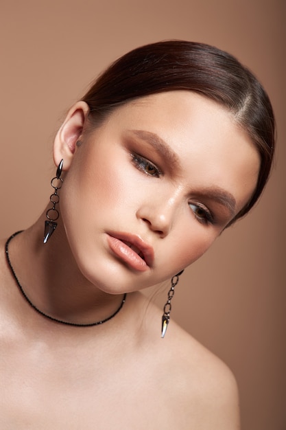 Beauty portrait of a woman with jewelry earrings in her ears