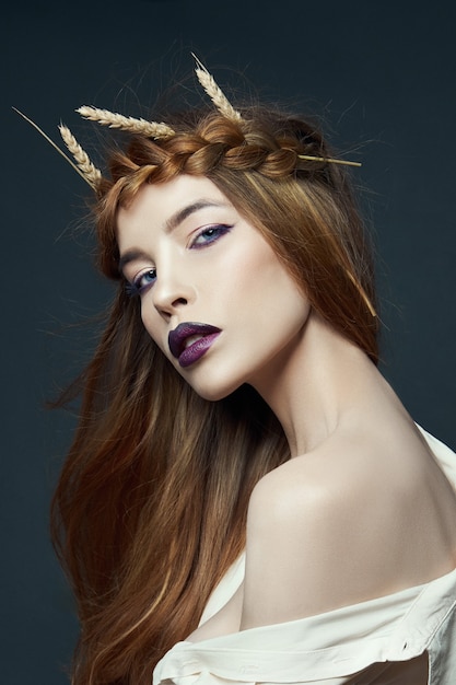 Beauty portrait woman with pigtail on her head and ears of wheat