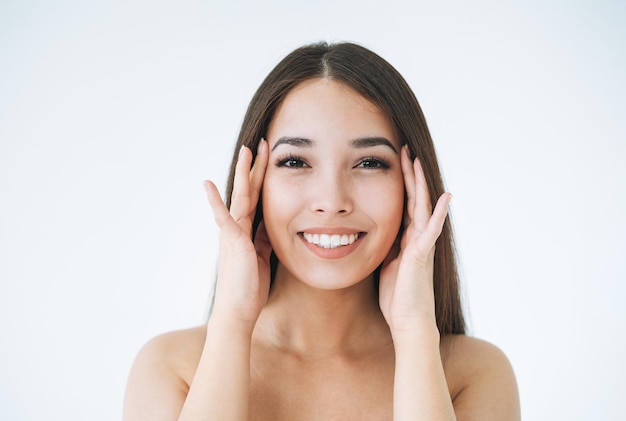 Beauty portrait of young asian woman with healthy dark long hair on white background isolated