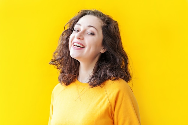 Beauty portrait young happy woman on yellow background isolated