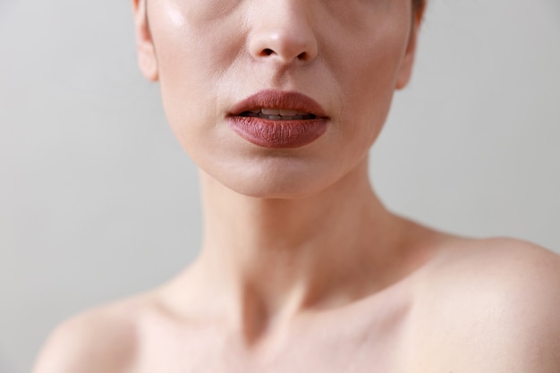  beauty portrait of a young, healthy, beautiful, fresh skinned caucasian woman on a grey wall