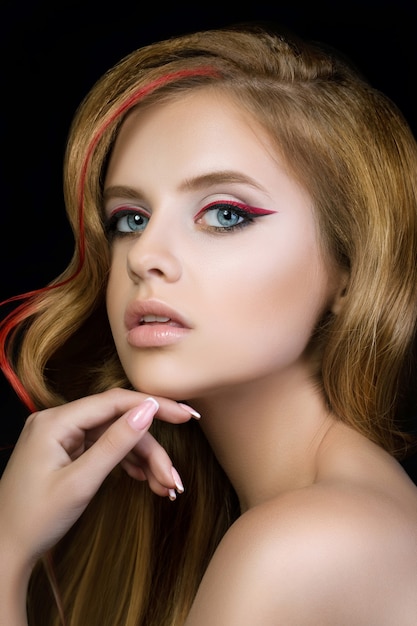 Beauty portrait of young pretty girl with red and black eyeliner arrows