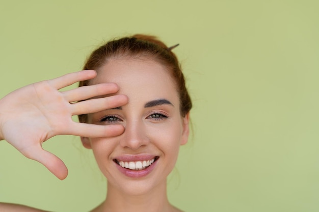 Beauty portrait of young topless red hair woman with bare shoulders on green background with perfect skin and natural makeup